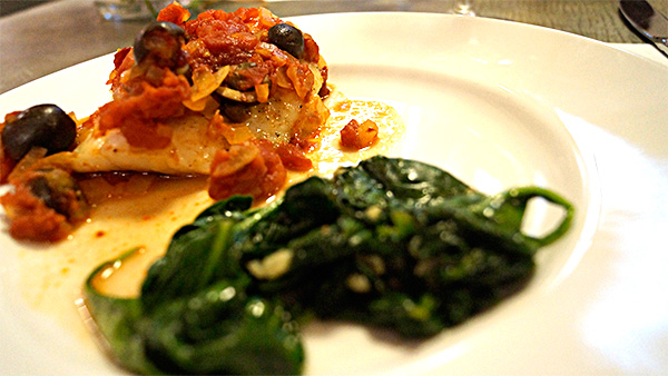 Laura originally wanted to poach cod in olive oil, but she soon realized that poaching fish on the stovetop isn’t the best idea. The fish itself is fatty, with its own omega oils. When combined with more fat from olive oil, it’s difficult to cook. Instead, they opted to use the oven, and made the Alaskan Cod with onion, tomato, black olives, capers and the Arbequina EVOO oil. The dish was also served with a savory garlic sautéed baby spinach and paired with chardonnay.