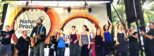 Musician Michael Franti strummed the guitar and sang while dozens of people practiced yoga on-stage.