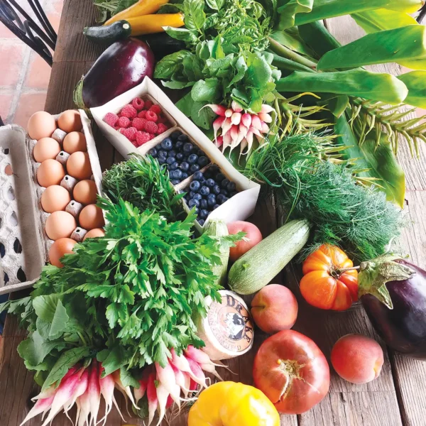 Eggs and fresh produce from the farmers market laid out on a table.