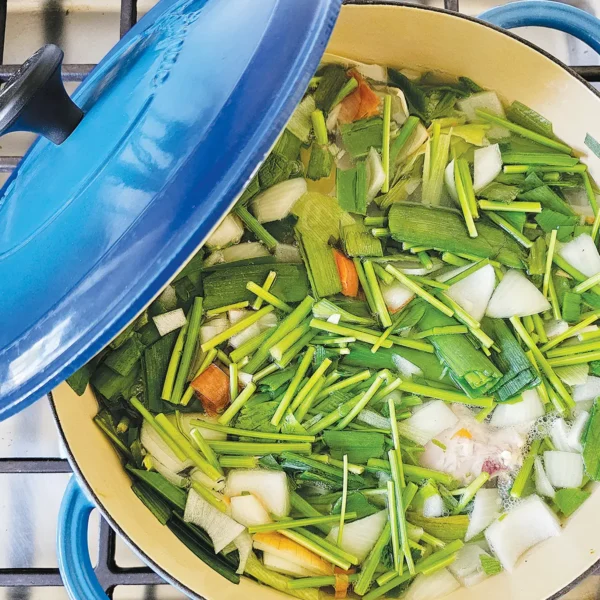 Vegetable stock in a blue stock pot on the stove.