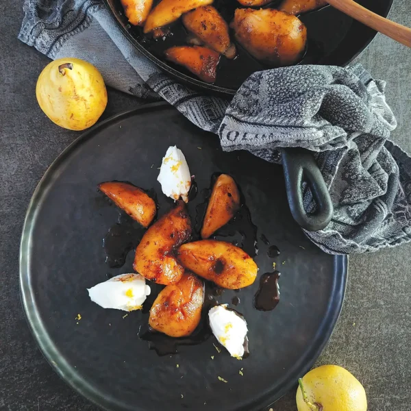 Pan-Roasted Pears with Vanilla and Cloves on a round plate.