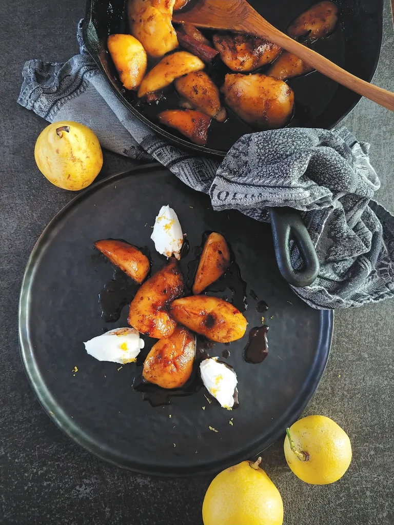 Pan-Roasted Pears with Vanilla and Cloves on a round plate.