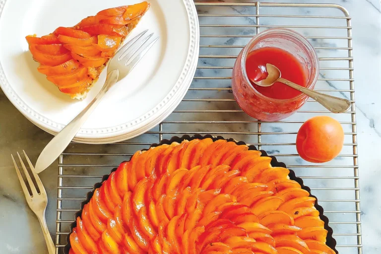 Sunflower apricot tart with a slice of the tart on a plate.