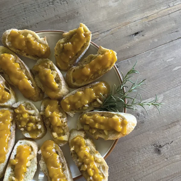 Apple crostini artfully arranged on a plate.