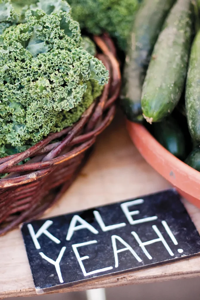 Bowls of kale and a sign readin Kale Yeah! on display.