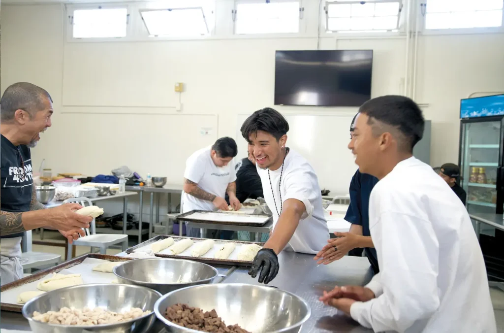 Freedom 4 Youth Culinary Program participants share a moment of laughter with their mentors at the SBCC Schott Center kitchen.