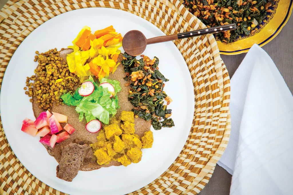 Ethiopian meal of various stewed meats and vegetables served on top of Ethiopian flatbread called injera.