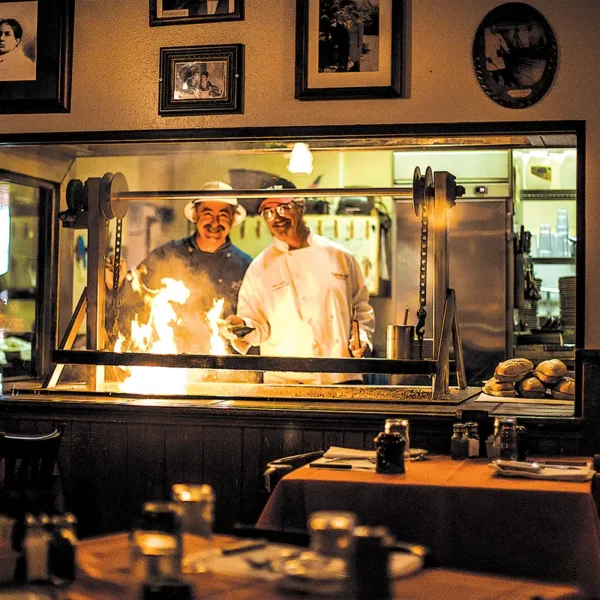 Frank and Bill Ostini behind the grill at the original Hitching Post I in Casmalia.