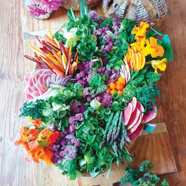 Artfully arranged plateau de crudités on a wooden serving board.