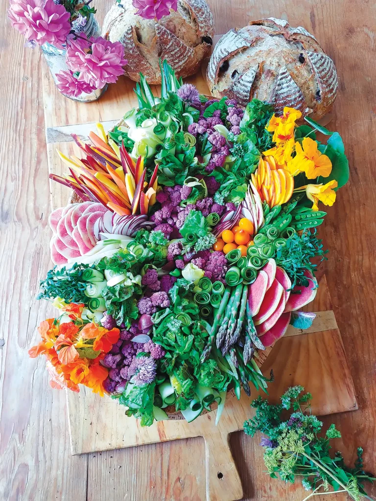 Artfully arranged plateau de crudités on a wooden serving board.