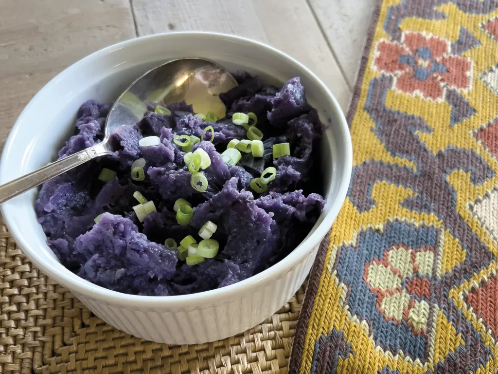 Purple skin-on mashed potatoes in a casserole dish.