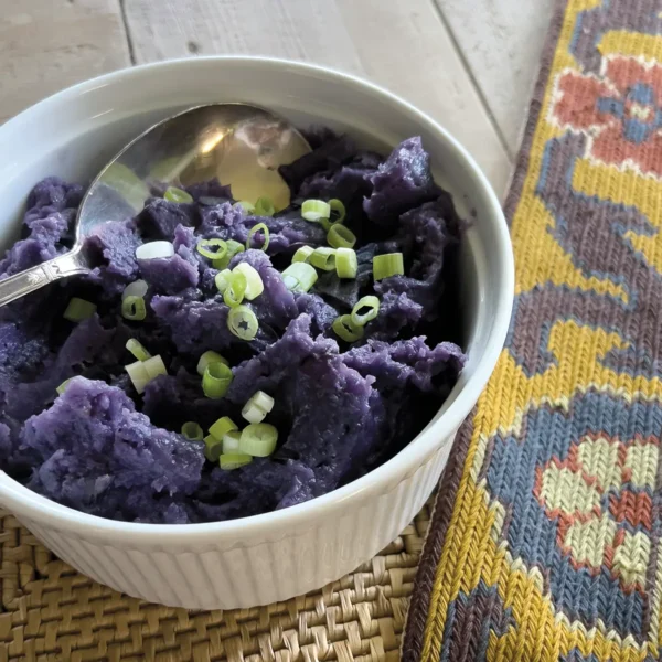 Purple skin-on mashed potatoes in a casserole dish.