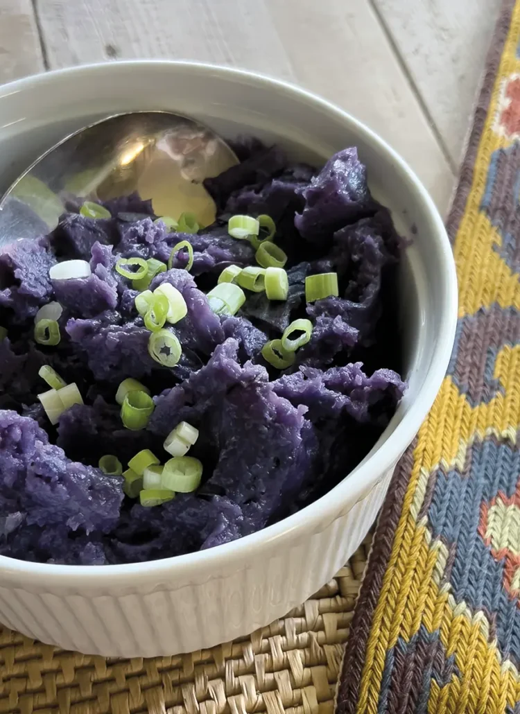 Purple skin-on mashed potatoes in a casserole dish.