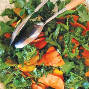 Roasted kale and grilled persimmon salad on a plate.