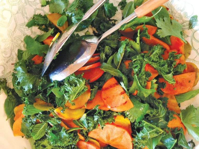 Roasted kale and grilled persimmon salad on a plate.