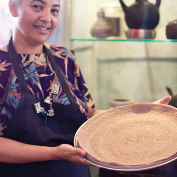 Serkaddis Alemu of Petit Valentien holds a platter of injera.