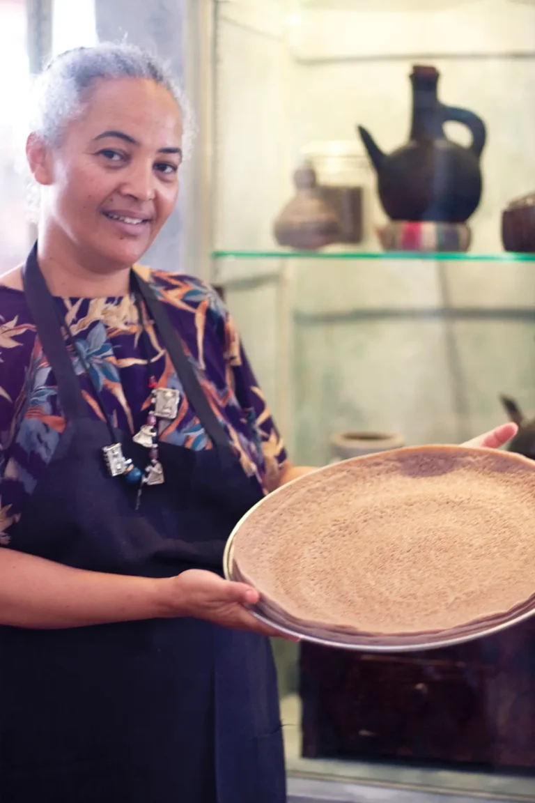 Serkaddis Alemu of Petit Valentien holds a platter of injera.