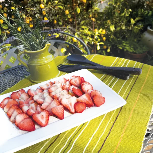 Sliced strawberries on a white rectangular plate.