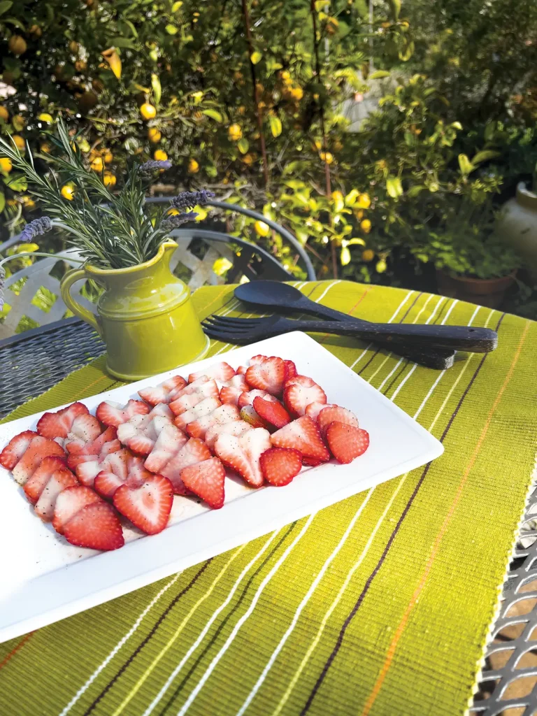 Sliced strawberries on a white rectangular plate.