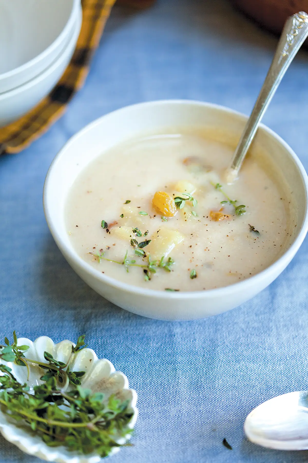 Cauliflower Soup with Stilton and Caramelized Pear Chutney on a blue tablecloth.