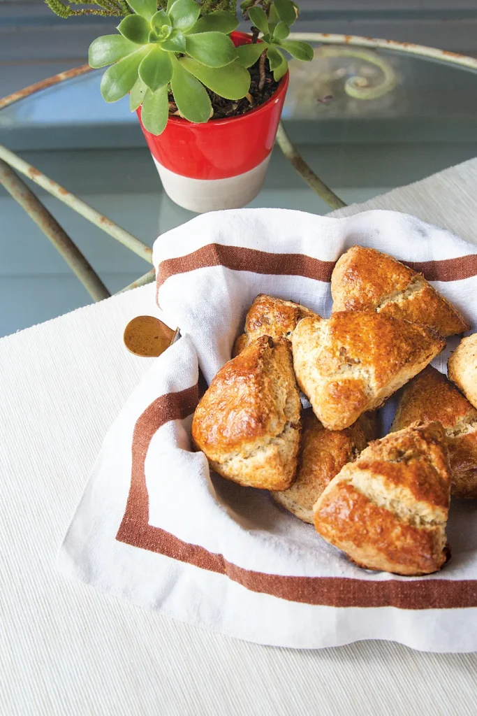 A pile of freshly baked winter scones in a cloth lined basket.