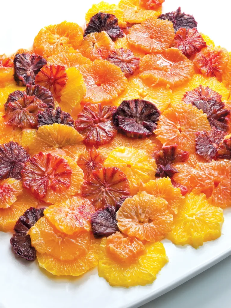 Citrus salad of oranges and blood oranges on a white serving plate.