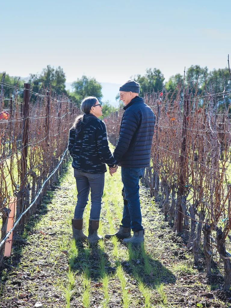 Laura Newman and Jim Tauber standing in the vineyard.