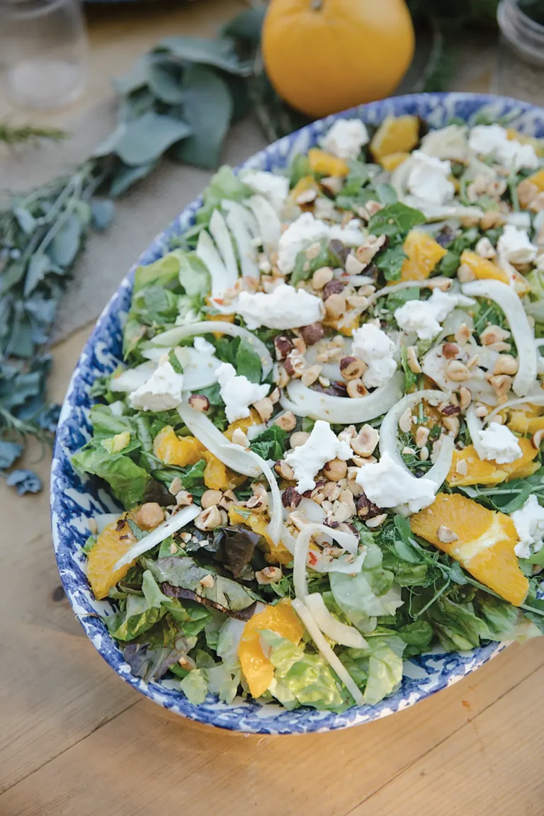 Oval bowl containing little gem salad with citrus vinaigrette.