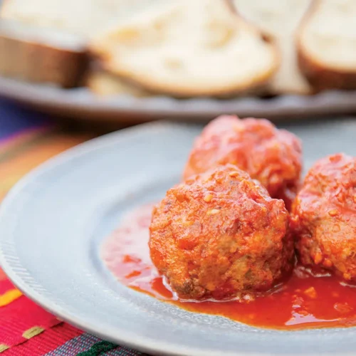 Rabbit Albondigas in Tomato Sauce on a pastel plate.