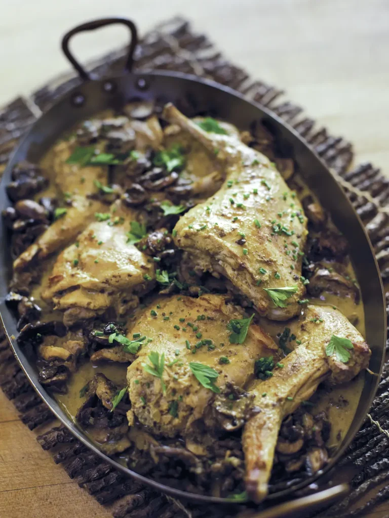 Roasting pan with rabbit in a mushroom and mustard sauce.