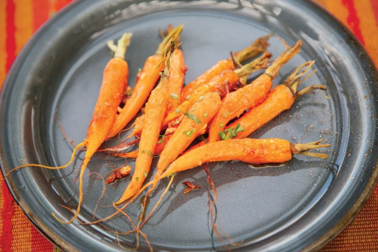 Orange baby carrots on a round plate.