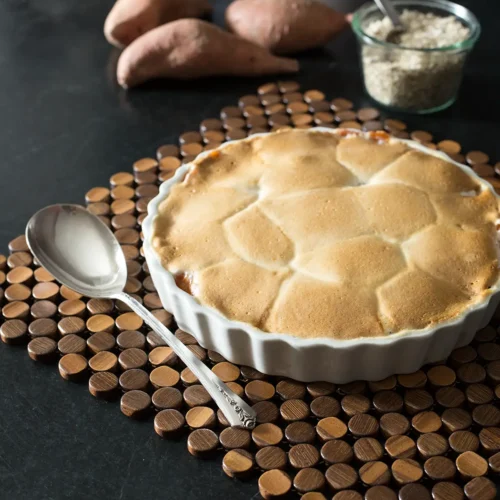 Sweet potatoes topped with marshmallows on a tablescape.