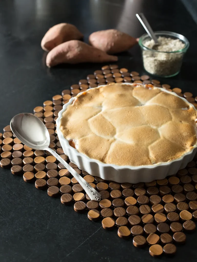 Sweet potatoes topped with marshmallows on a tablescape.