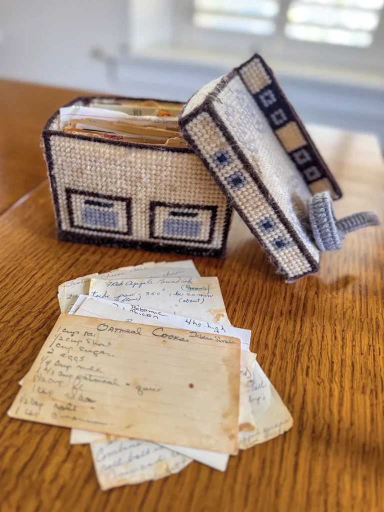 Crocheted recipe box shaped like a stove and recipe cards on a countertop.