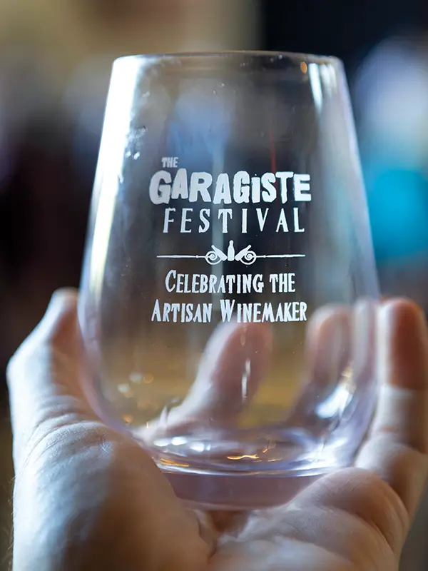 Hand holding a Gragiste Festival wine glass.