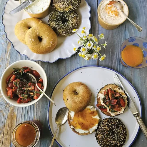 Overhead tablescape with bagels topped with various toppings.