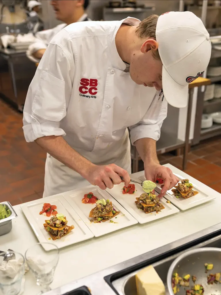 Culinary student Kellmer McFarling prepares the corn crisp and bluefin tuna appetizer.