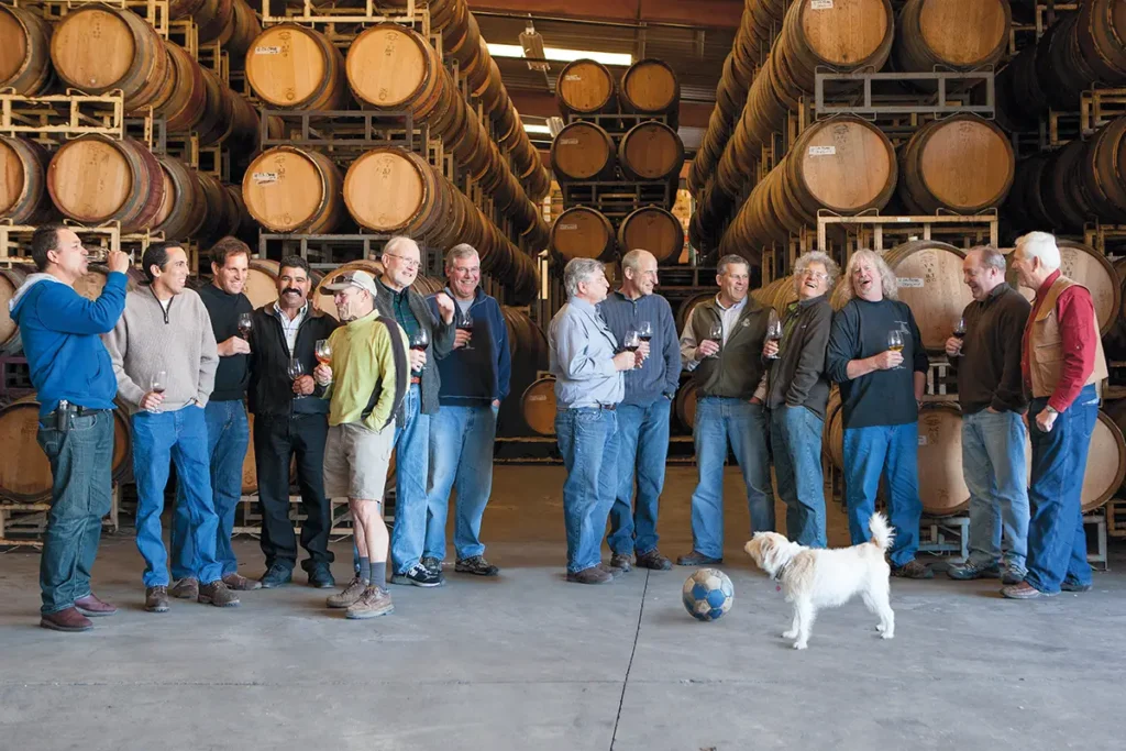 Zaca Mesa alumni gather in the barrel room for a group photo.