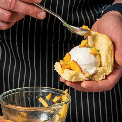 Chef scooping gelato and accoutrements onto a brioche slider bun.