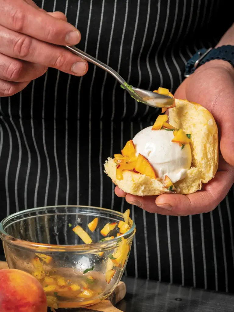 Chef scooping gelato and accoutrements onto a brioche slider bun.