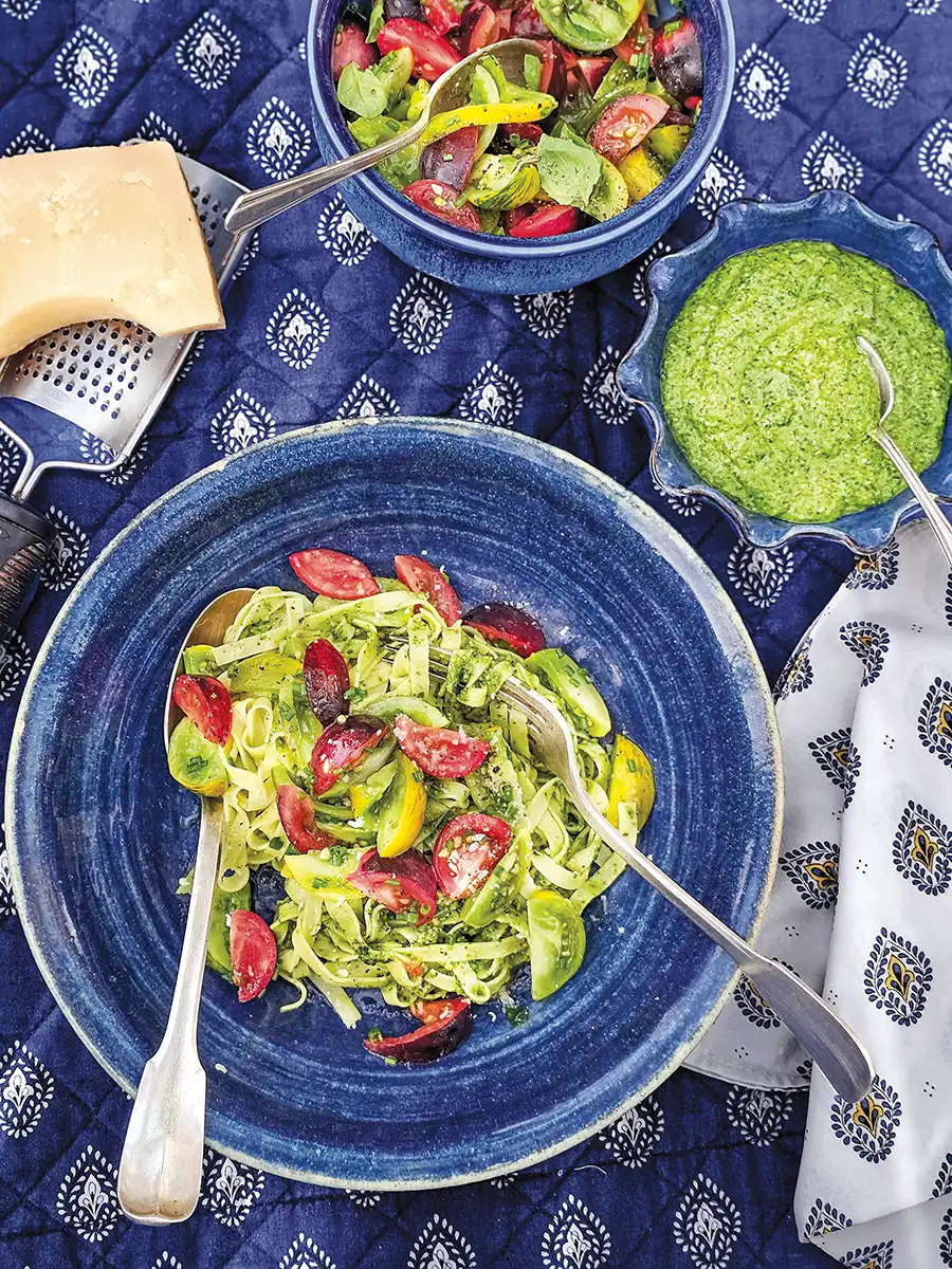 Bowls of salad on a blue patterned tablecloth.
