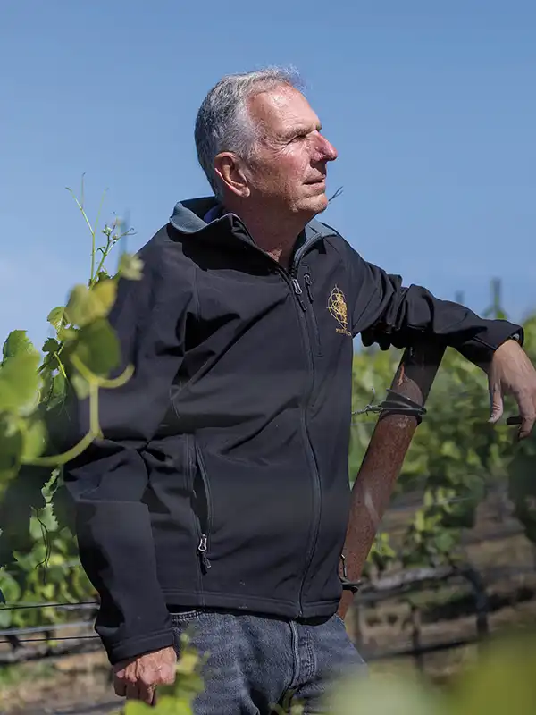 Jogn Wagner among the grapes, looking out.