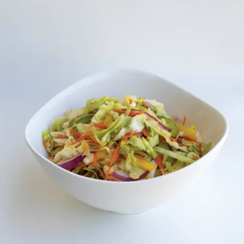 A big white bowl of Metro's Sweet & Sour Carolina Coleslaw against a white background.