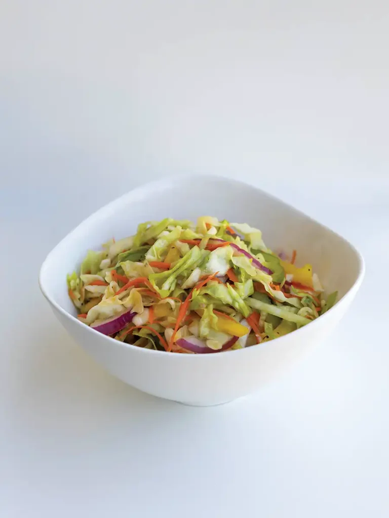A big white bowl of Metro's Sweet & Sour Carolina Coleslaw against a white background.