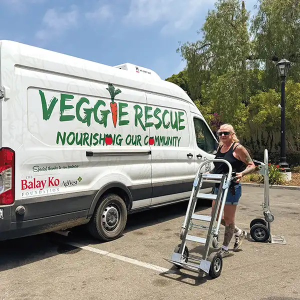 Olga Leatherbury with a dolly about to unload the Veggie Rescue van.