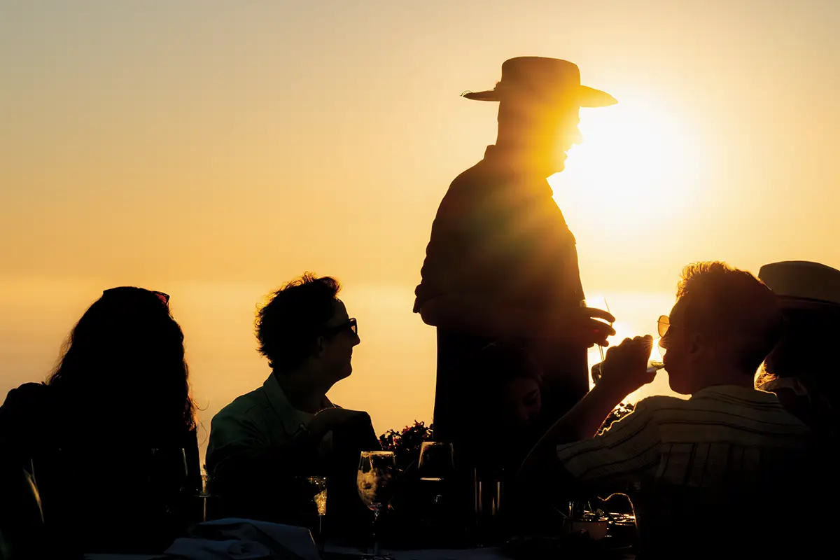 Silhouettes of founder Jim Denevan and guests against the setting sun.