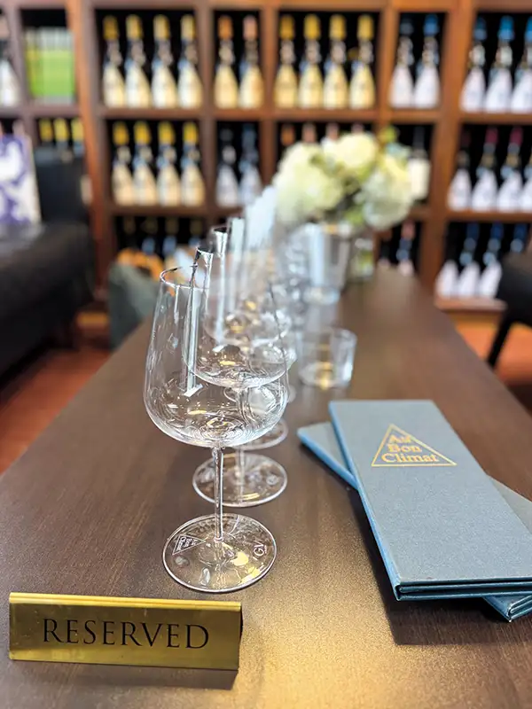 Reserved sign on a table with a row of wine glasses and an ABC menu.