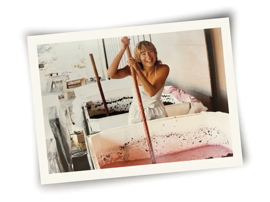 Lane Tanner stirring pressed grape juice in a vat.