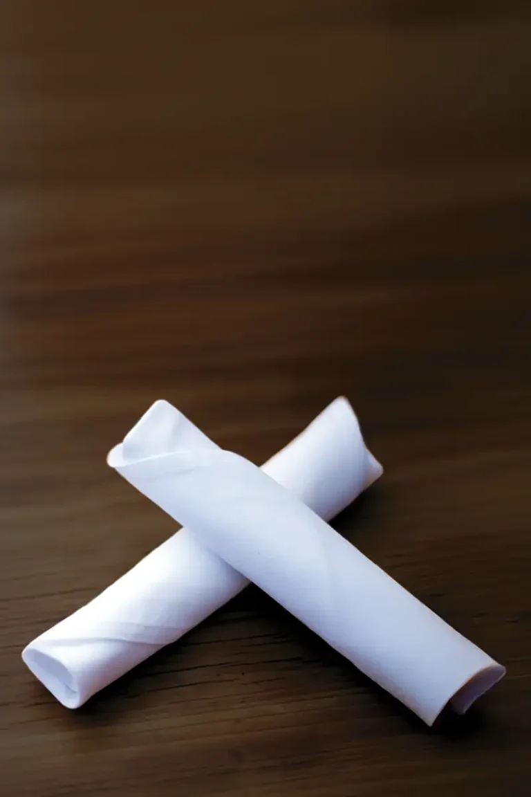 Rolled up and crossed white napkins.