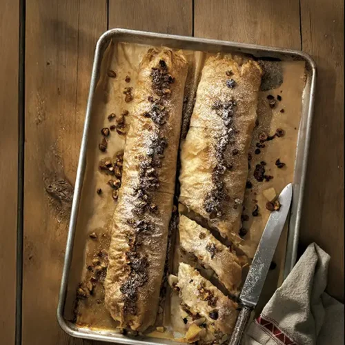 Spiced apple and pear strudel on a wooden table.